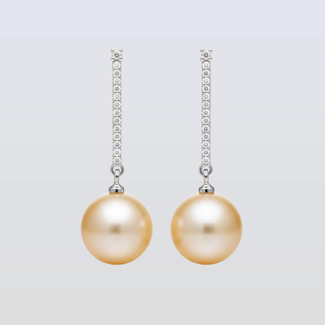 Pair of pearl earrings with diamond accents on a light gray background