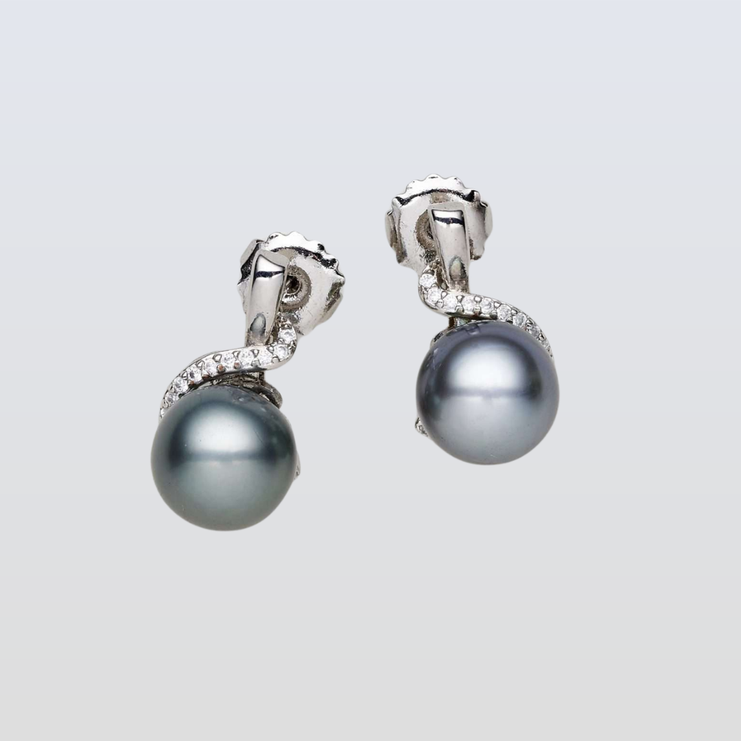 Pair of pearl earrings with silver and diamond accents on a light gray background