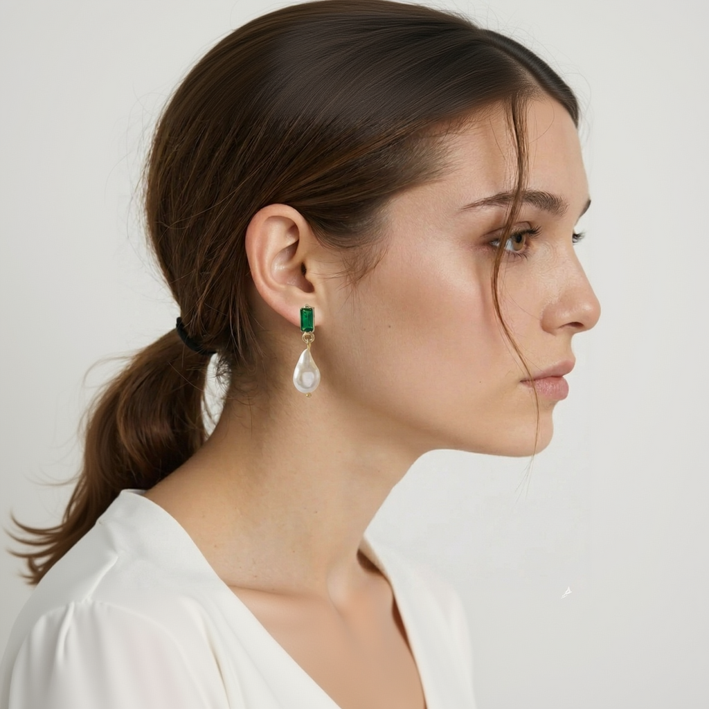 Close-up of a woman wearing green and white earrings against a neutral background