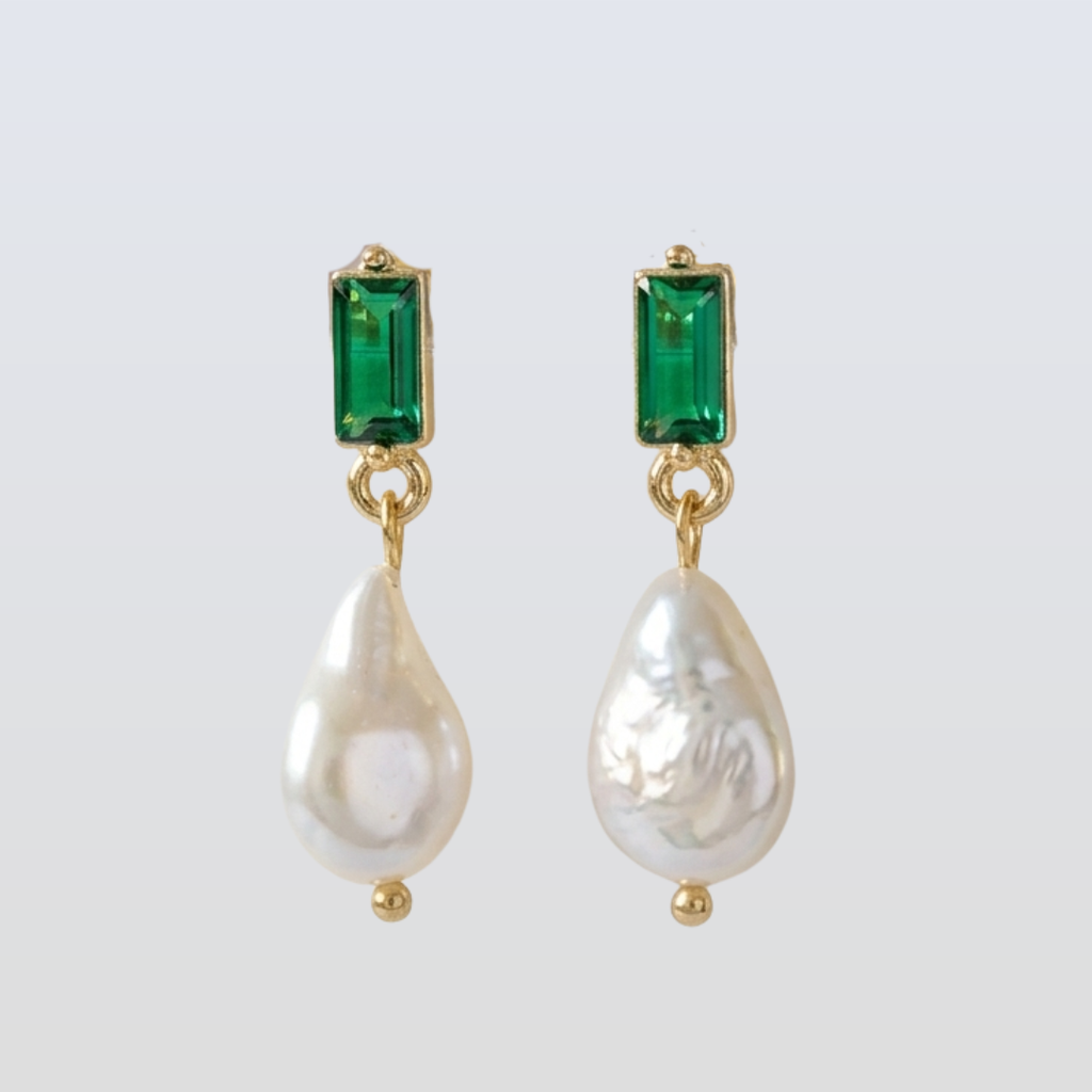 Pair of earrings with green gemstones and pearl drops on a white background