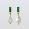 Pair of earrings with green gemstones and pearl drops on a white background