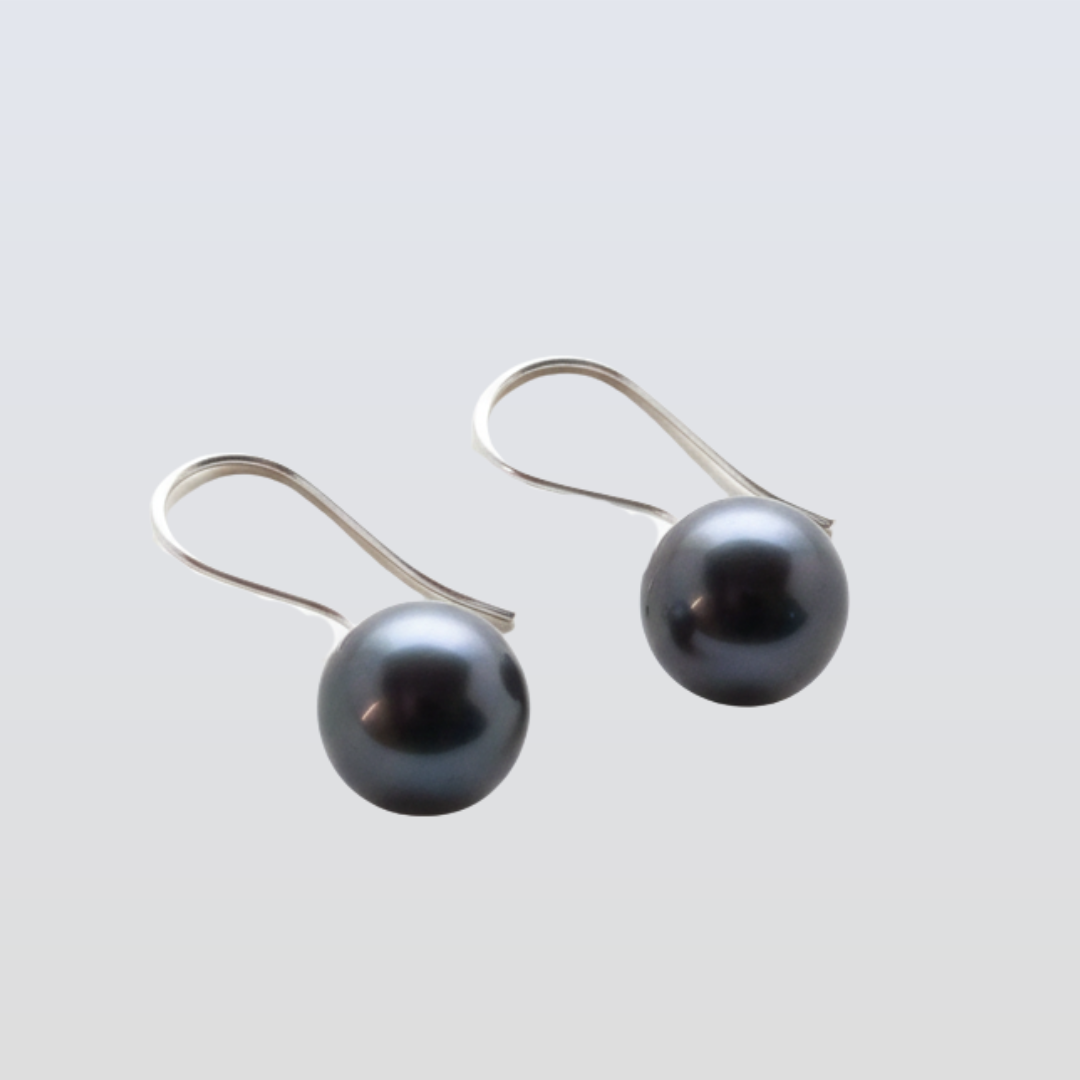 Pair of silver earrings with black faceted beads on a white background