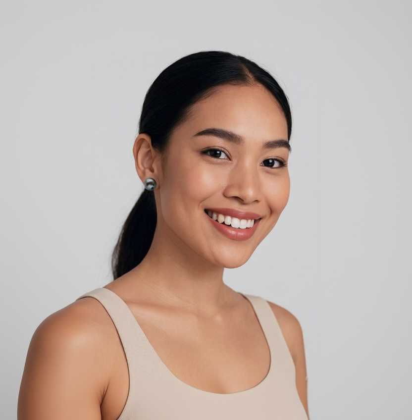 Woman with a ponytail wearing a beige tank top against a plain background