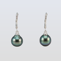 Pair of black pearl earrings on a light gray background