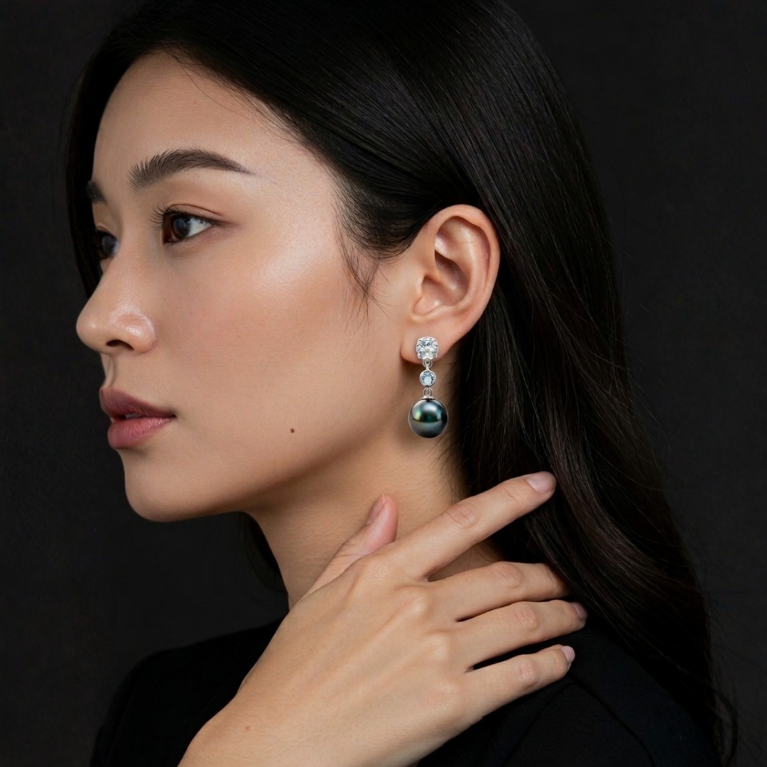 Woman wearing a pair of earrings with a dark background