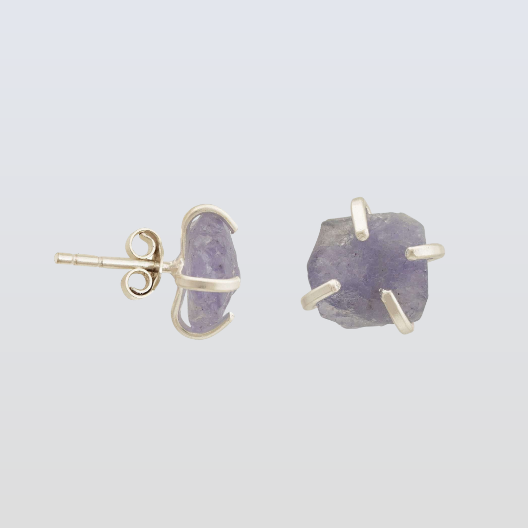 Pair of earrings with purple stones and gold accents on a light gray background