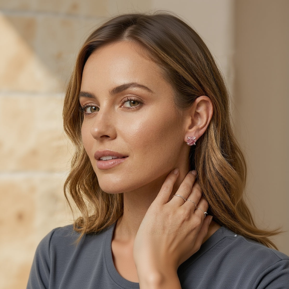 Woman wearing pink earrings with a neutral background
