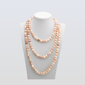 Two layered pearl necklaces on a mannequin bust against a white background
