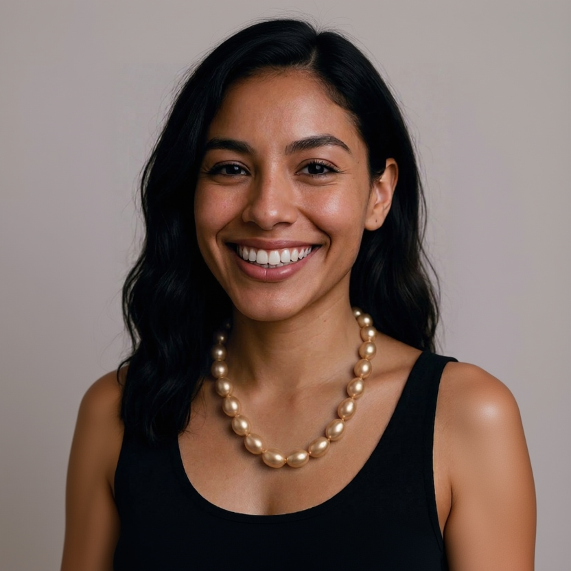 Woman wearing a pearl necklace against a neutral background