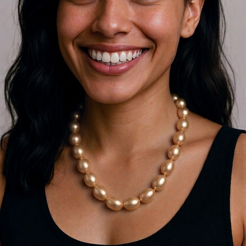 Woman wearing a pearl necklace against a neutral background