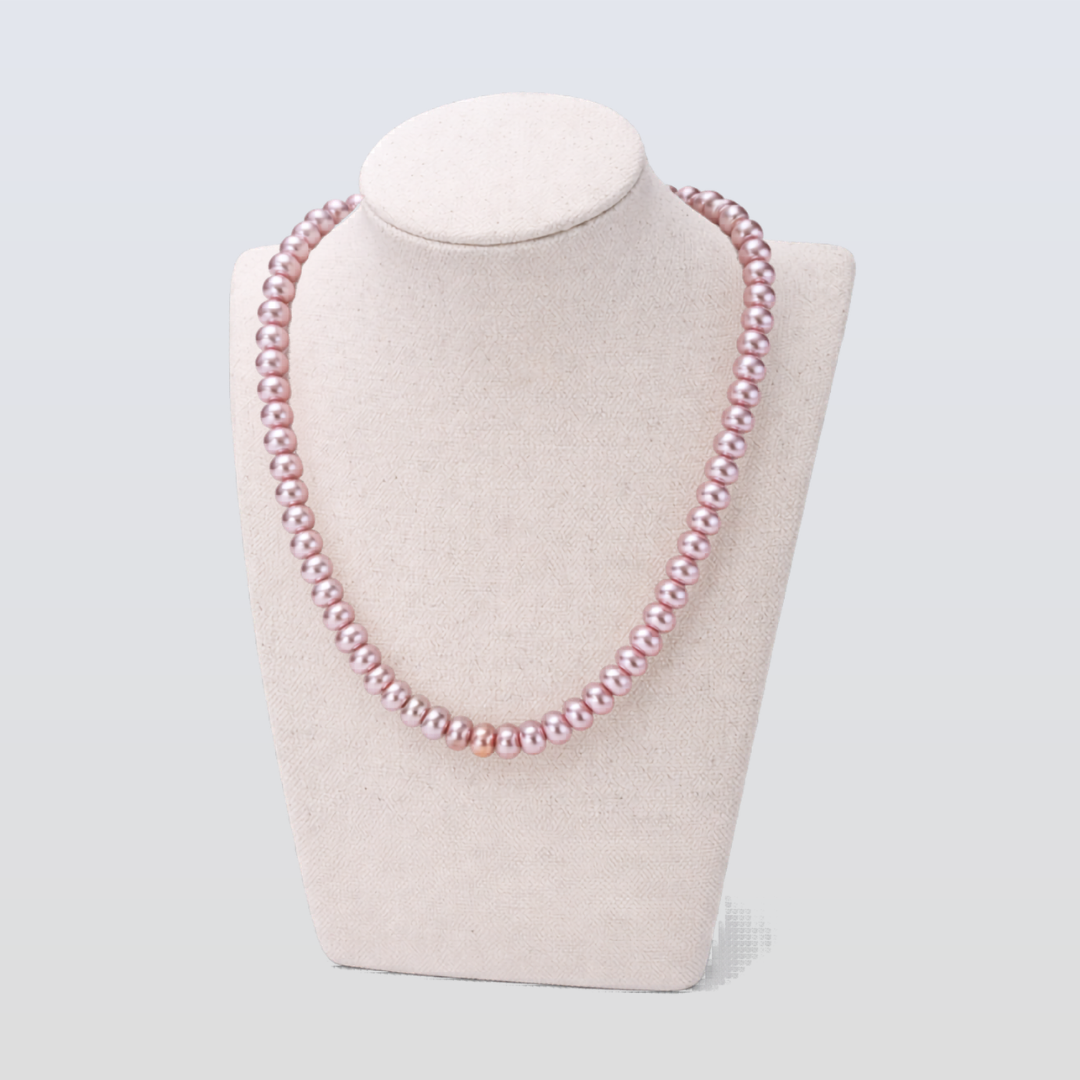 Pink pearl necklace on a mannequin bust against a light gray background