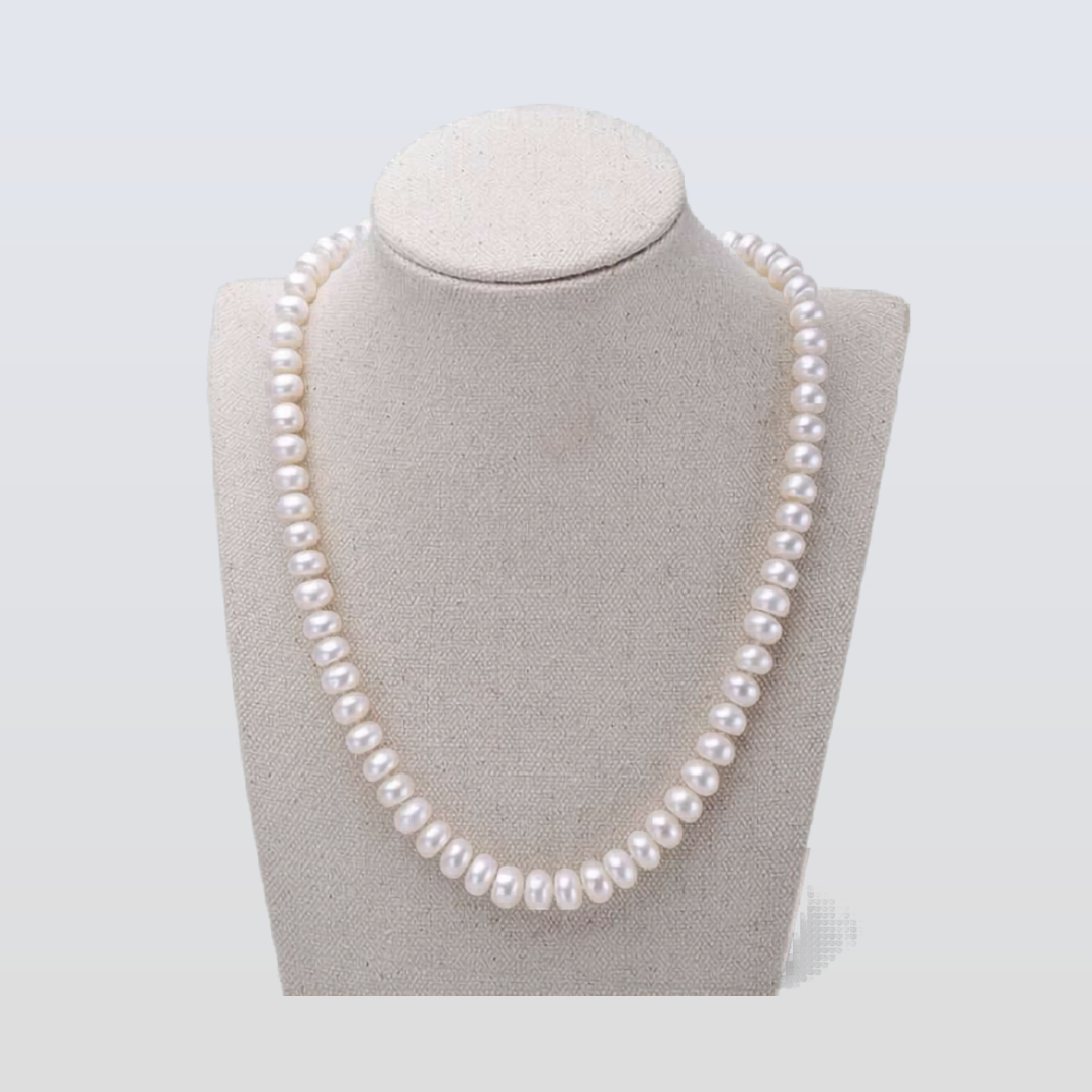 Pearl necklace on a gray bust against a light gray background