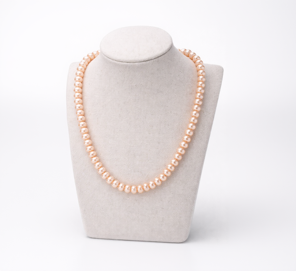 Pearl necklace on a mannequin bust against a white background