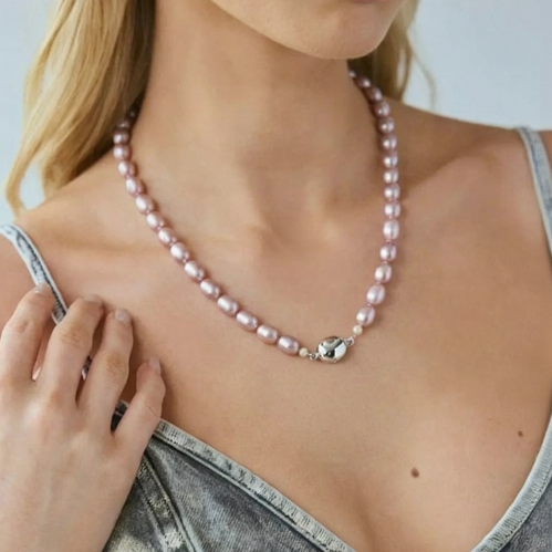 Woman wearing a pearl necklace with a plain background