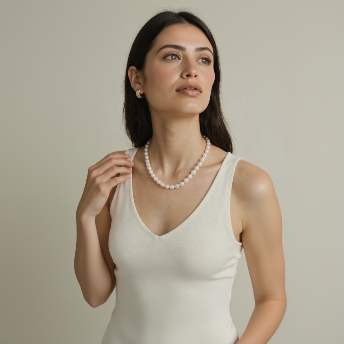 Woman wearing a pearl necklace with a plain background