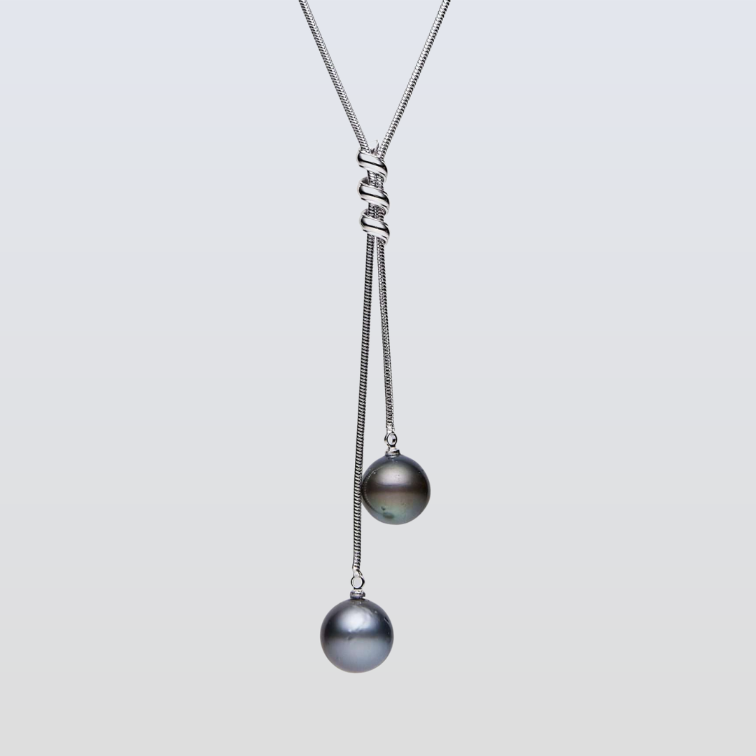 Necklace with two pearls on a light gray background