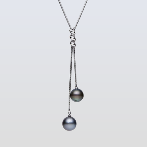 Necklace with two pearls on a light gray background