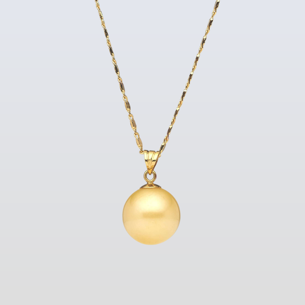 Gold necklace with a round pendant on a light gray background