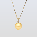 Gold necklace with a round pendant on a light gray background