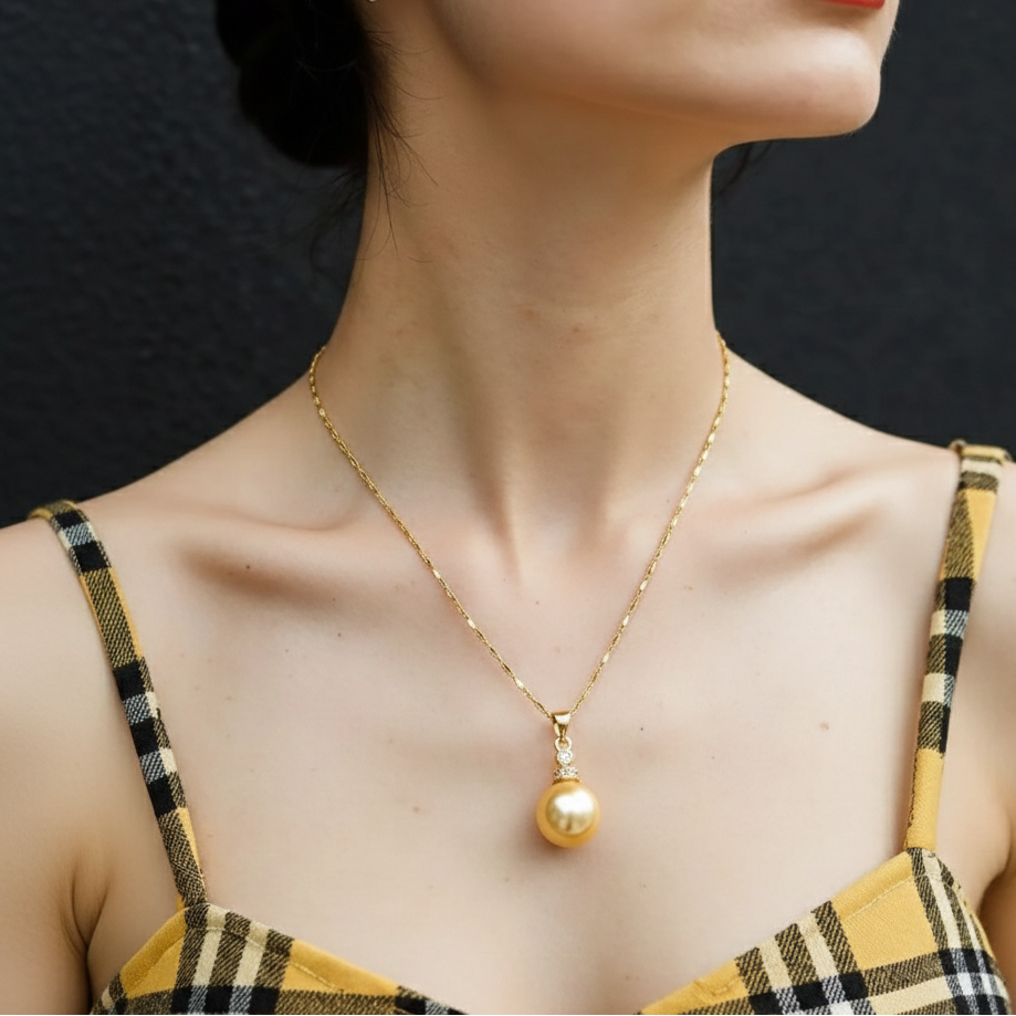 Woman wearing a gold necklace with a pendant against a dark background