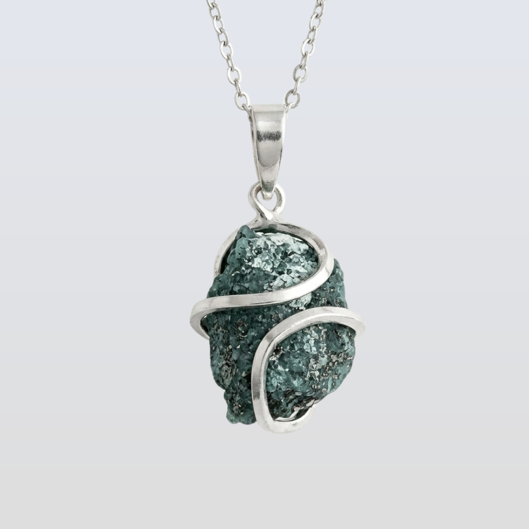 Green stone pendant with silver wire wrapping on a light gray background