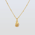 Gold necklace with a pendant on a light gray background