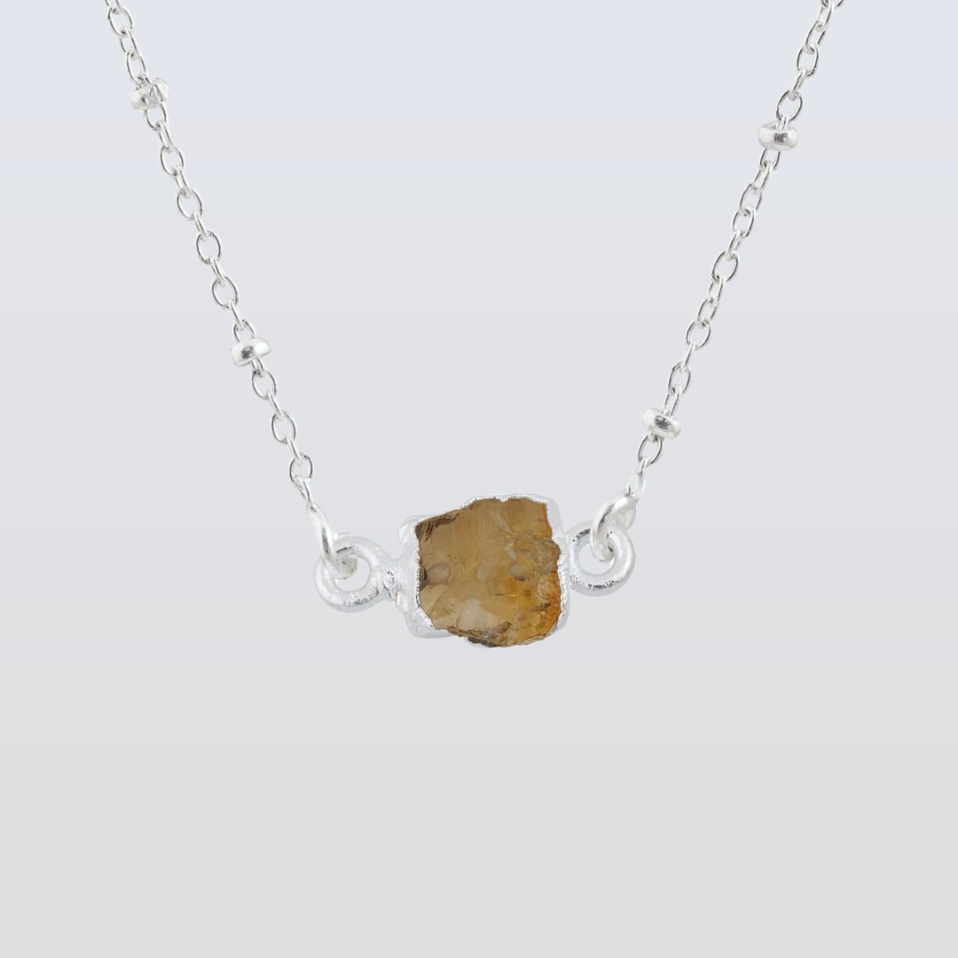 Necklace with a rough stone pendant on a light gray background