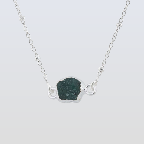 Rose gold necklace with a unique pendant on a white background