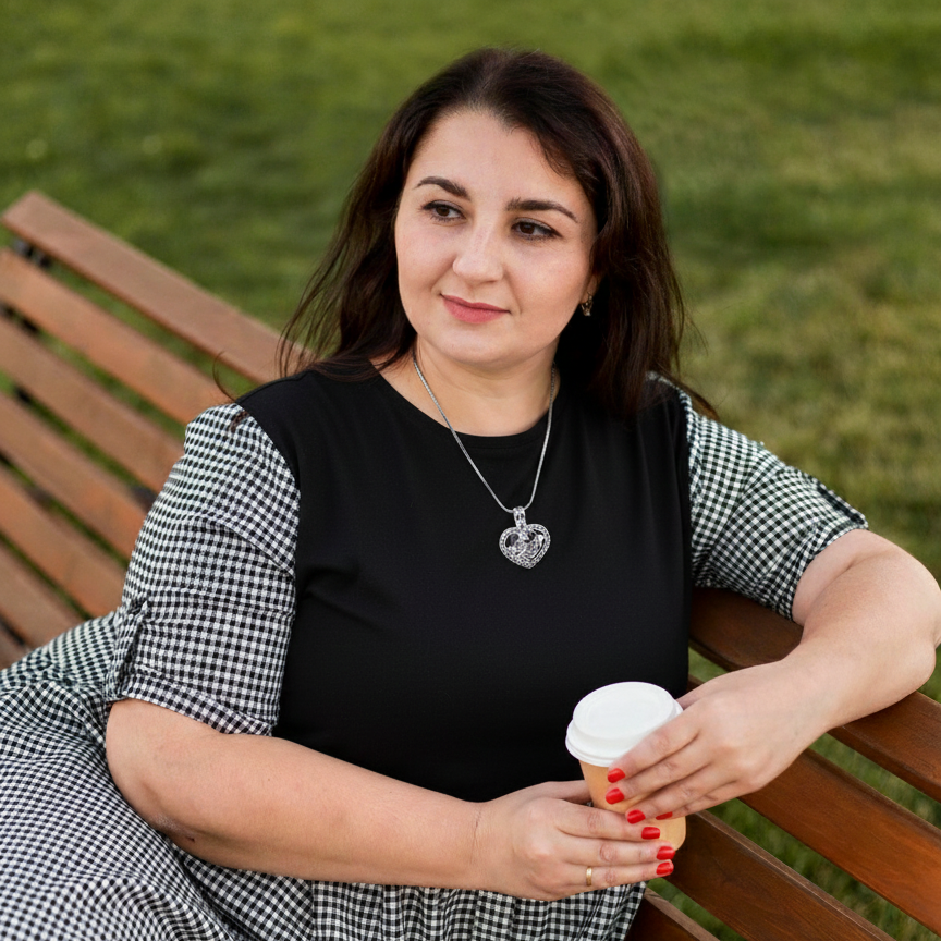 Woman sitting on a bench holding a coffee cup outdoors