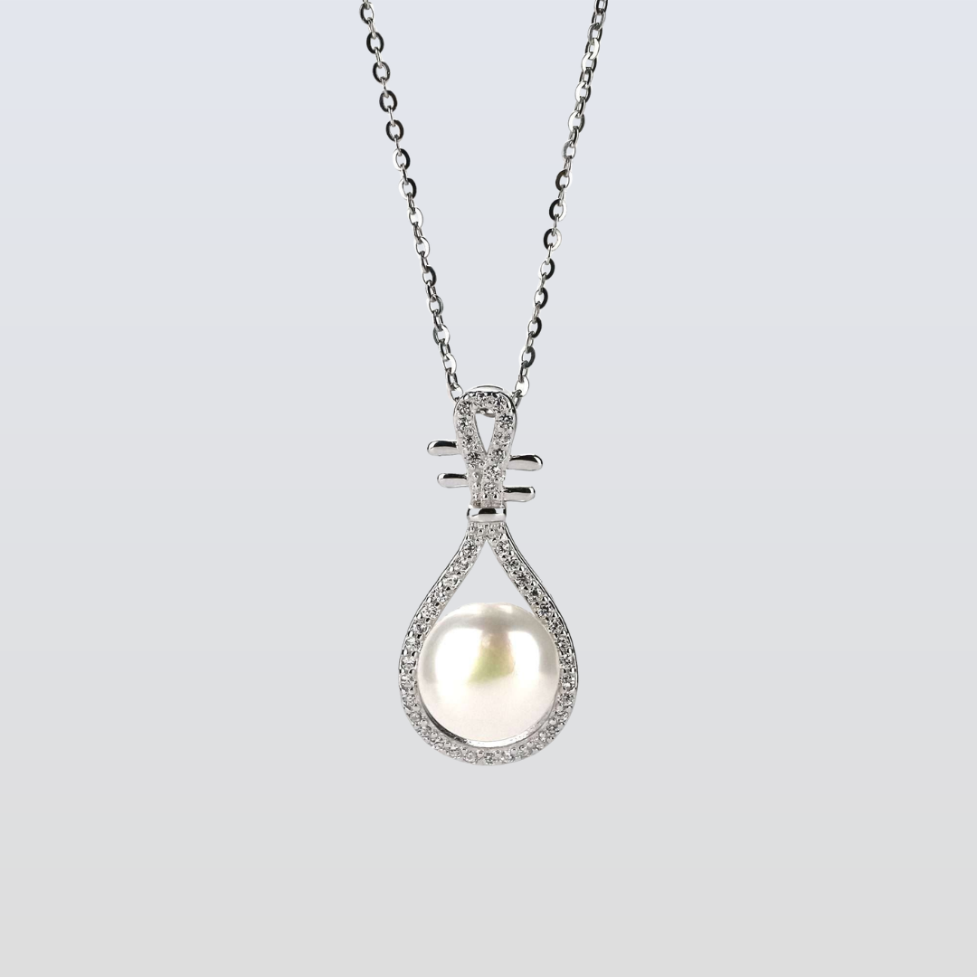 Pearl necklace with silver teardrop pendant on a light gray background