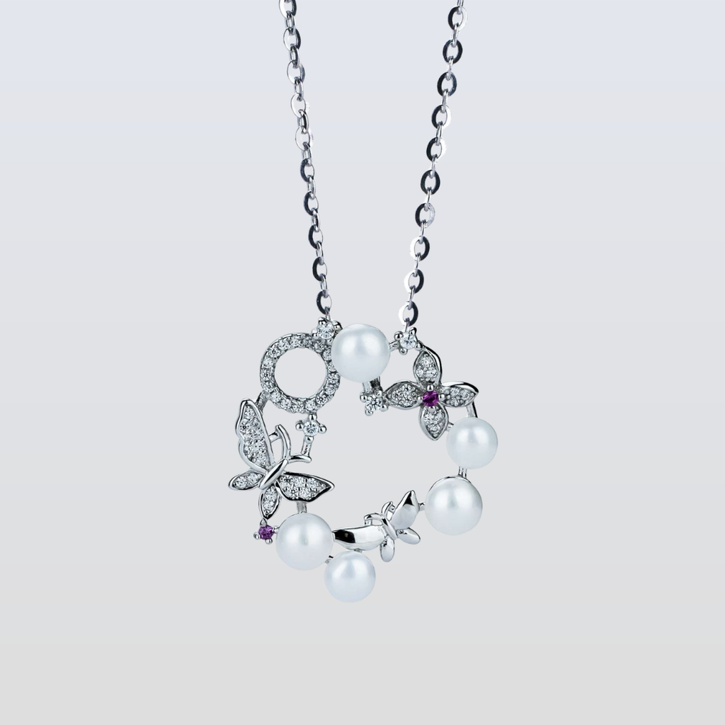 Pearl necklace with butterfly pendants on a light gray background