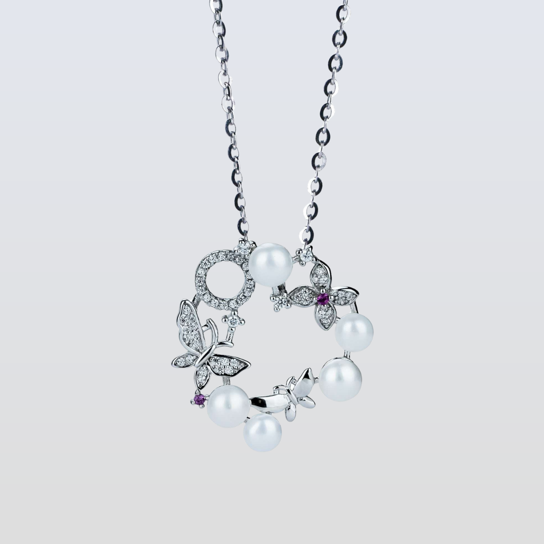 Pearl necklace with butterfly pendants on a light gray background