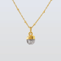 Gold necklace with a textured pendant on a light gray background