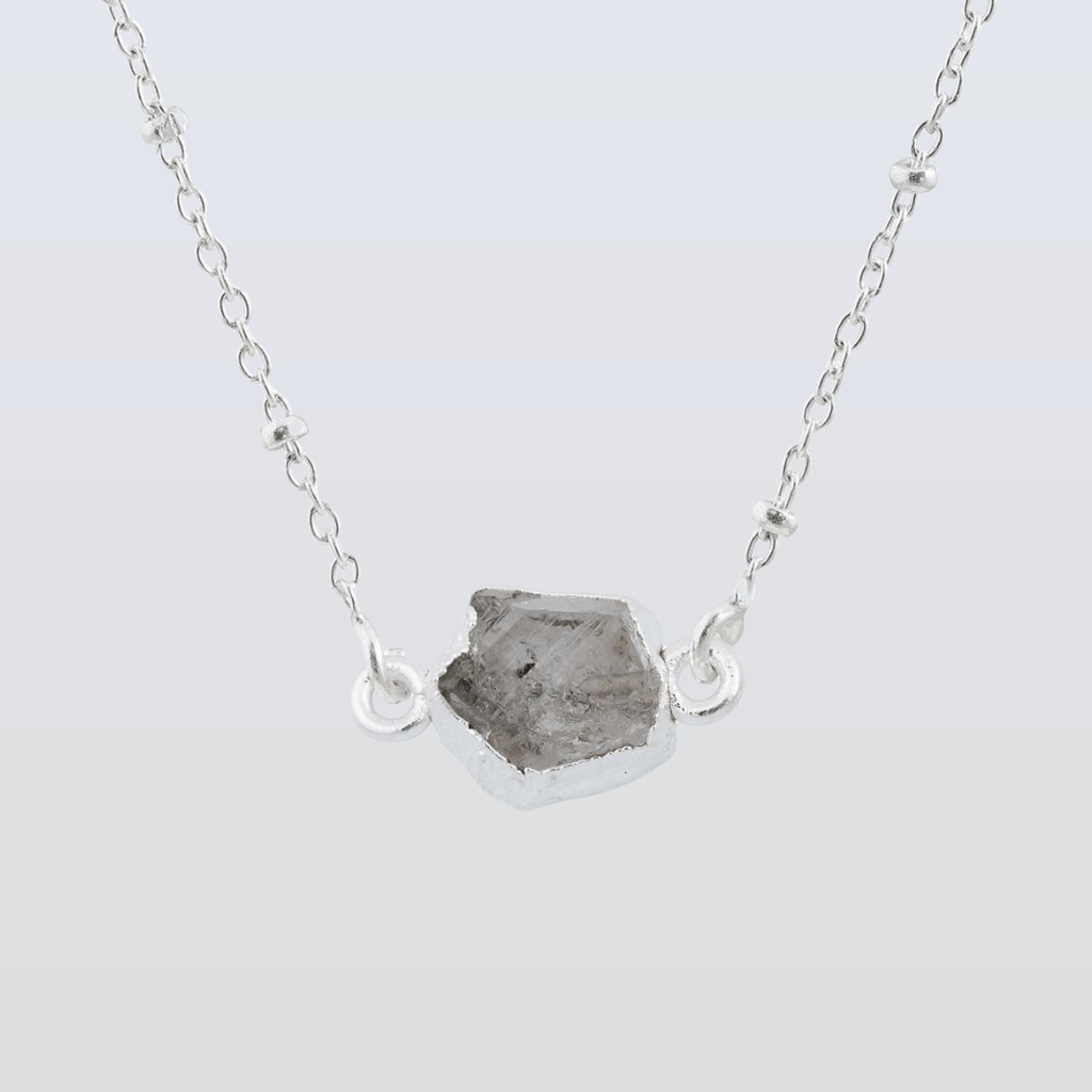 Necklace with a raw stone pendant on a light gray background
