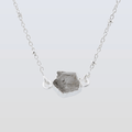 Necklace with a raw stone pendant on a light gray background