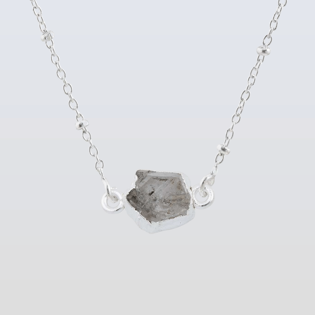 Necklace with a raw stone pendant on a light gray background