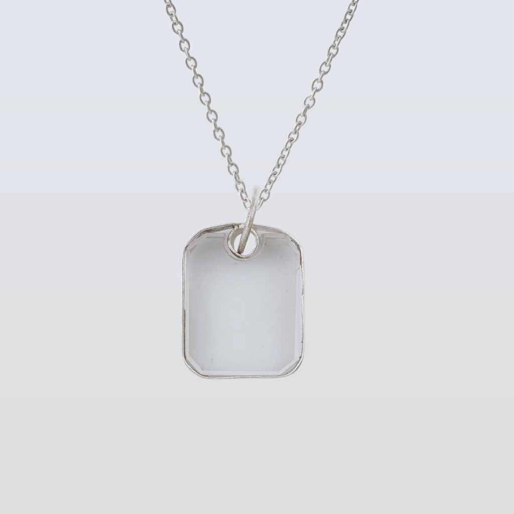 Silver necklace with a rectangular pendant on a light gray background
