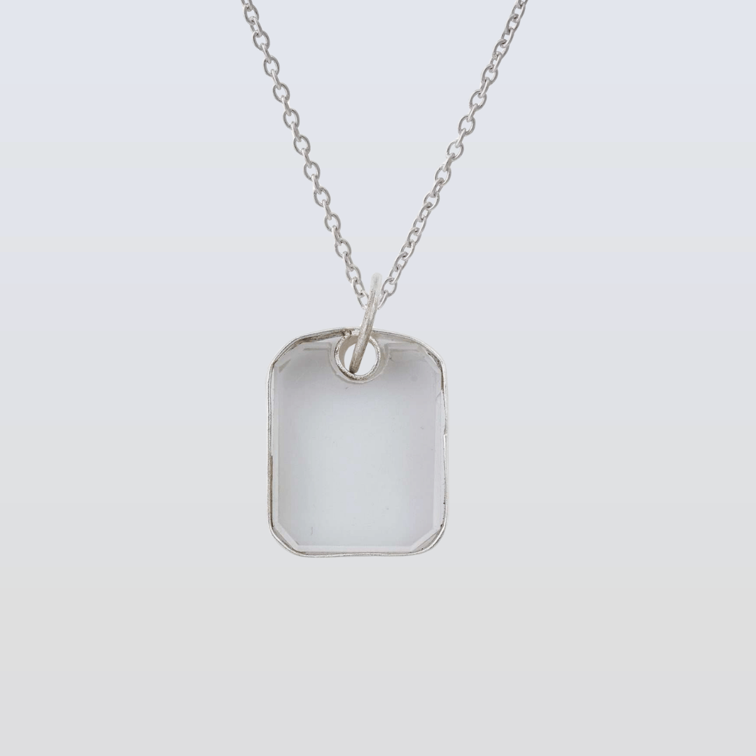 Silver necklace with a rectangular pendant on a light gray background