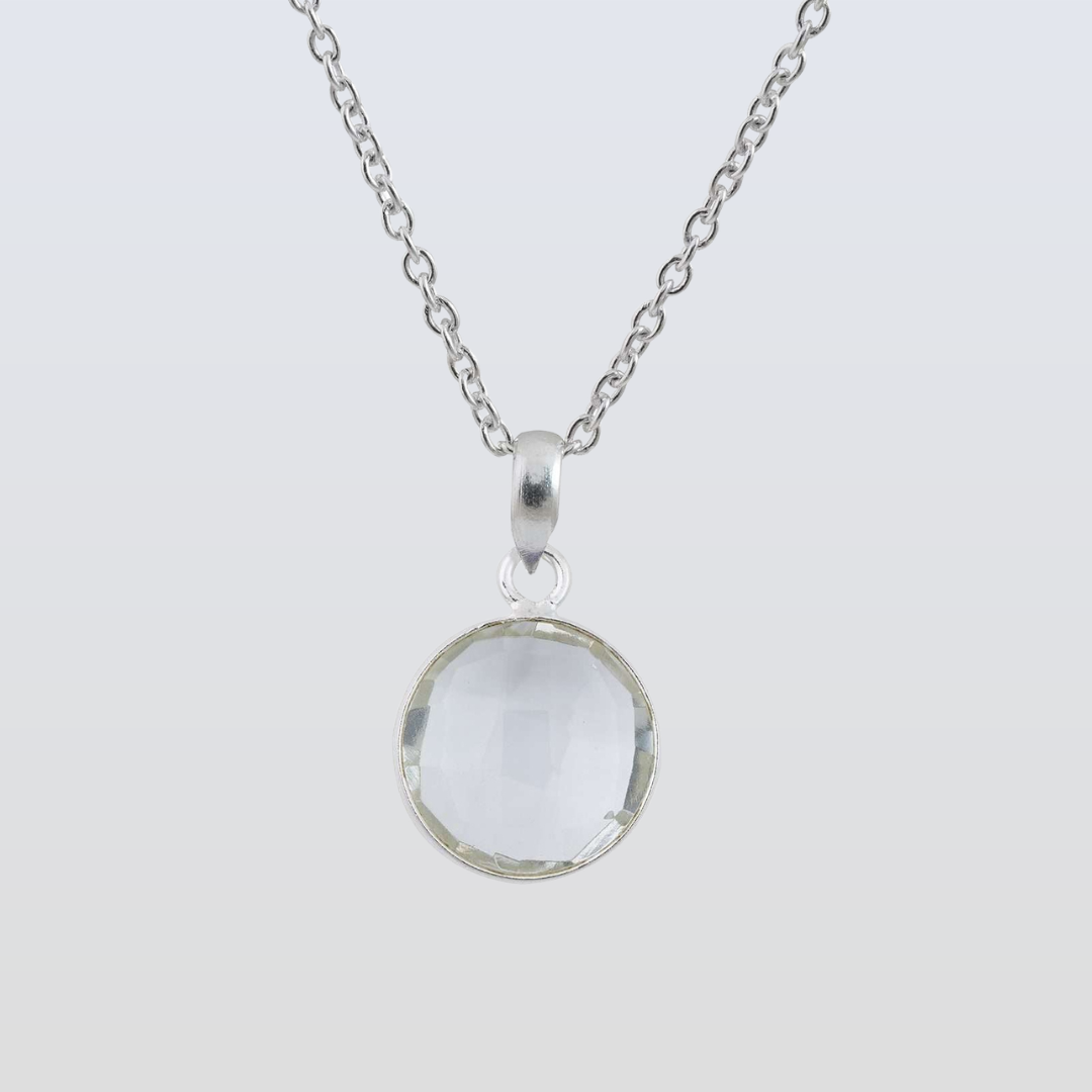 Silver necklace with a round pendant on a light gray background