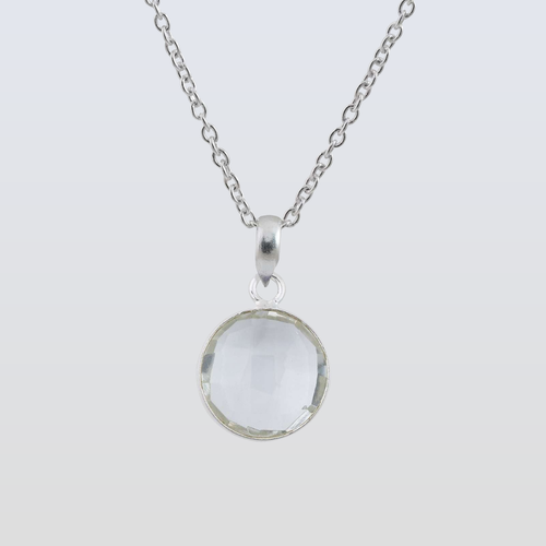 Silver necklace with a round pendant on a light gray background
