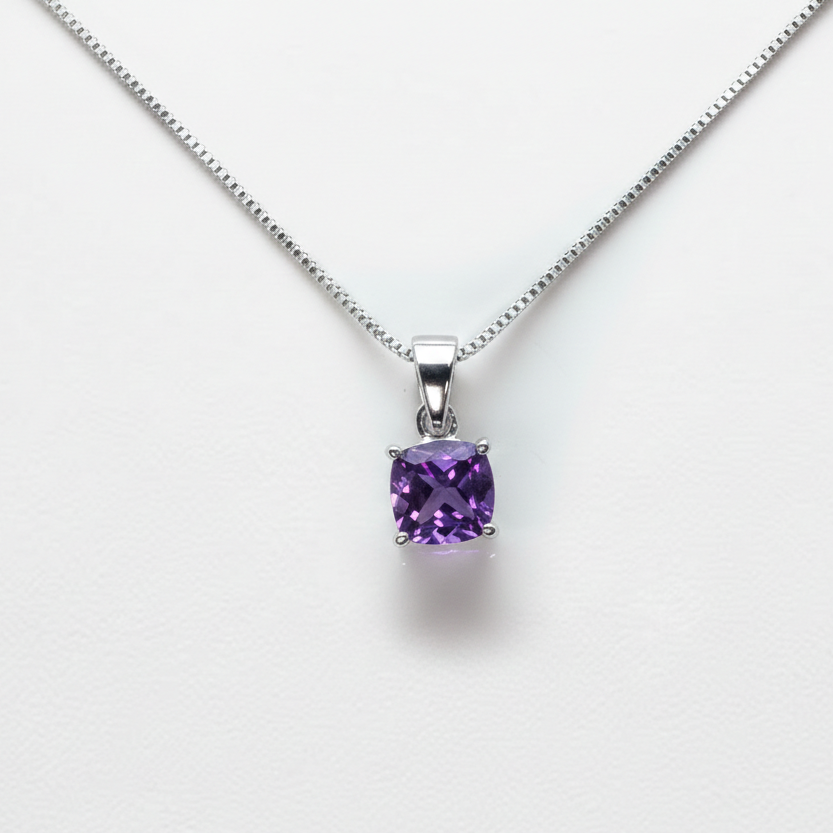 Silver necklace with a purple gemstone pendant on a white background