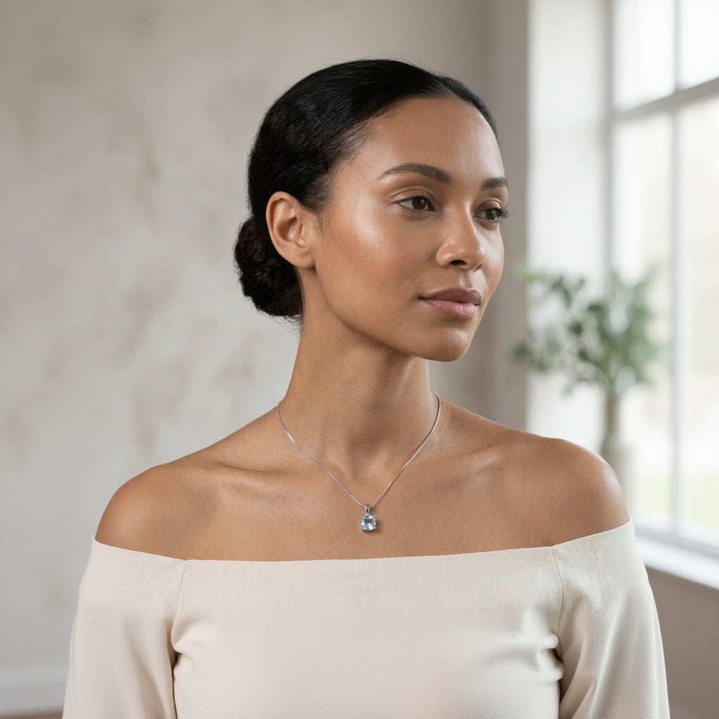 Woman wearing a necklace with a pendant against a neutral background