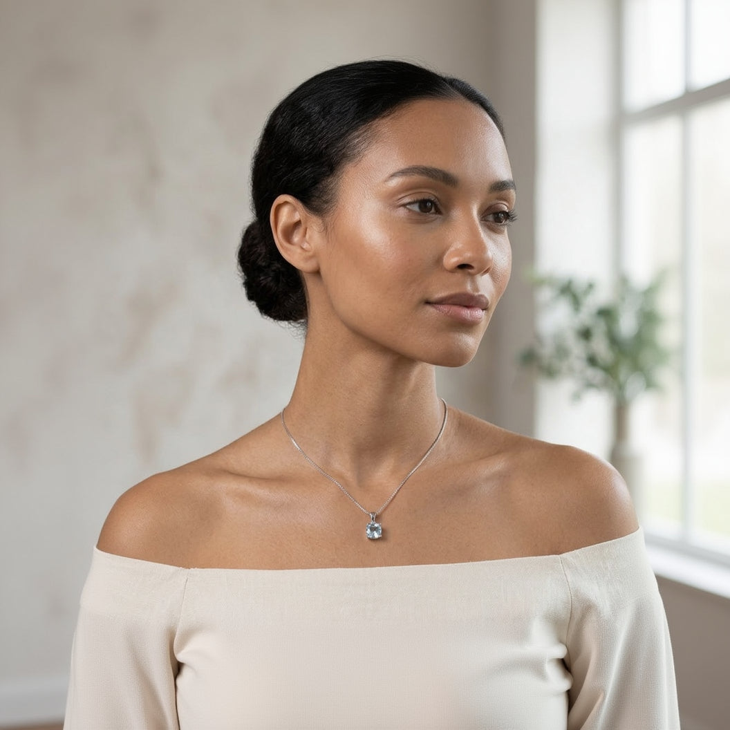 Woman wearing a necklace with a pendant against a neutral background
