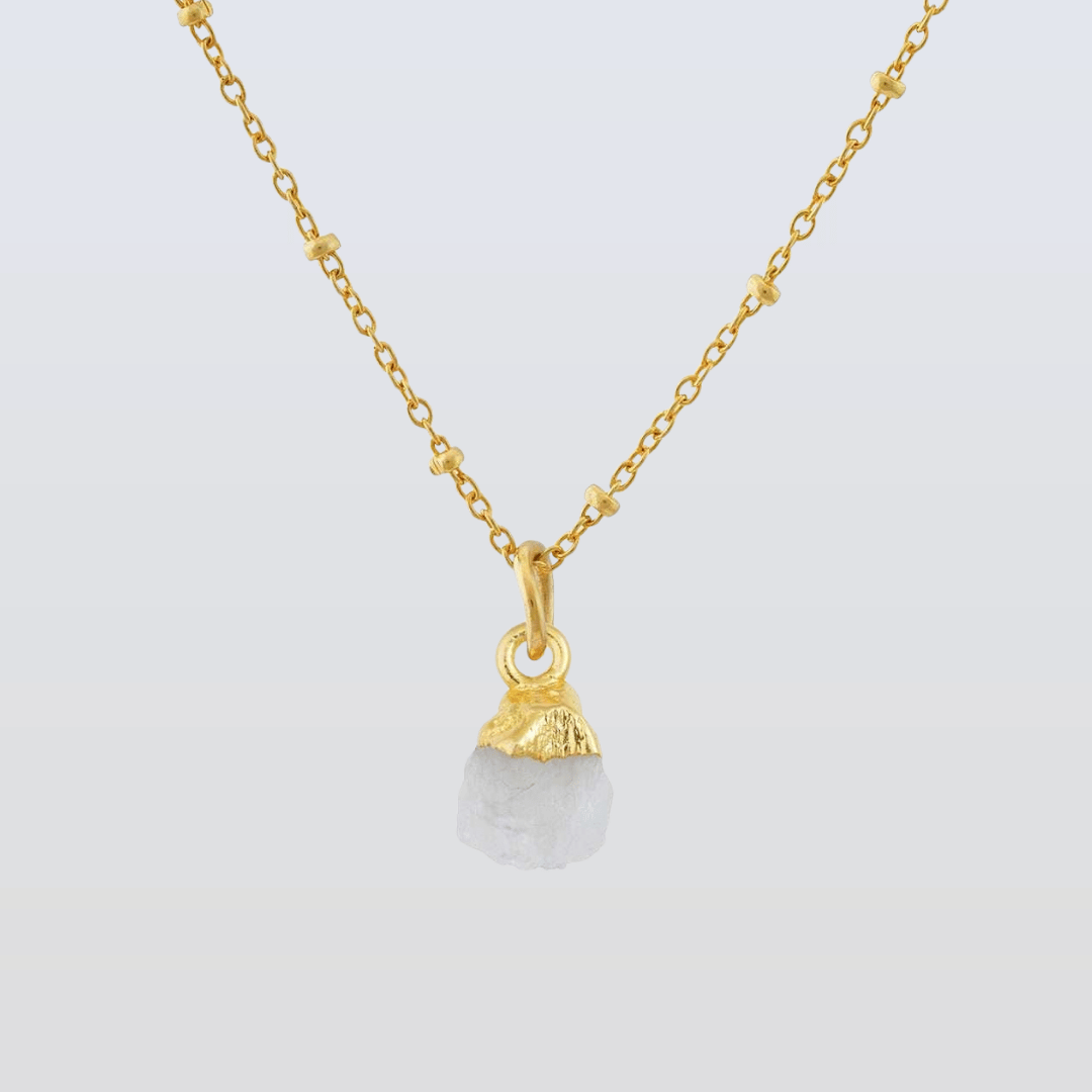 Gold necklace with a pendant on a light gray background