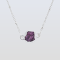 Necklace with a purple gemstone pendant on a light gray background