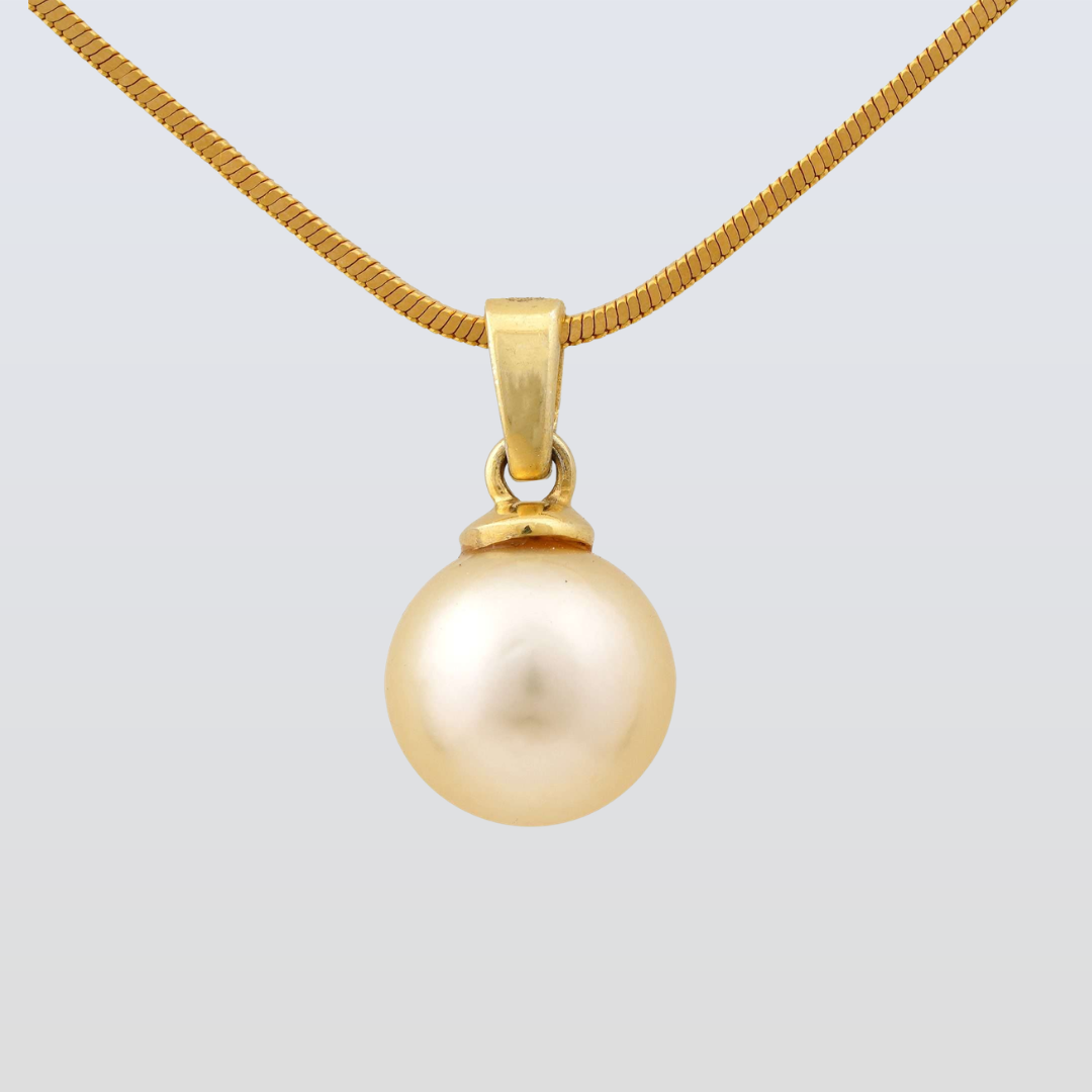 Gold necklace with a gold pearl pendant on a light gray background
