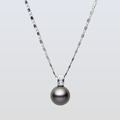 Pearl necklace with a silver chain on a light gray background