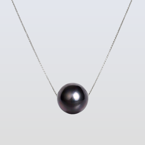 Necklace with a single black pearl on a light gray background