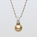 Gold pearl necklace with diamond pendant on a light gray background
