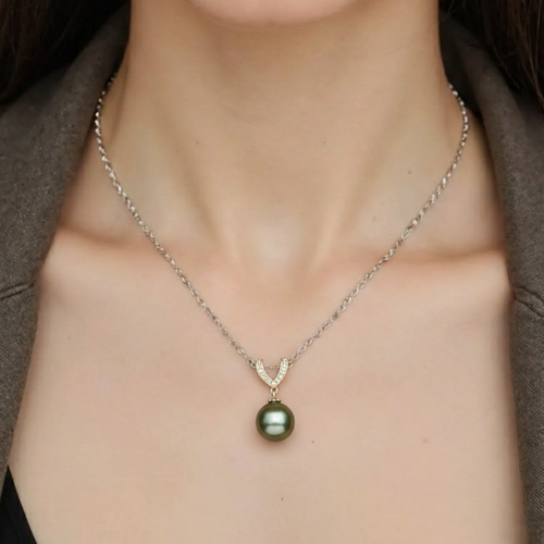 Necklace with a green pearl pendant worn by a person